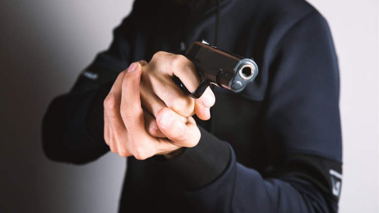 man holding a black pistol in his hand